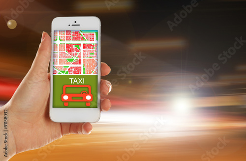 Hand holding mobile smart phone with interface taxi on night background