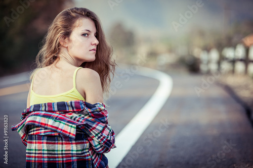 Trendy Hipster Girl Relaxing on the road at the day time.