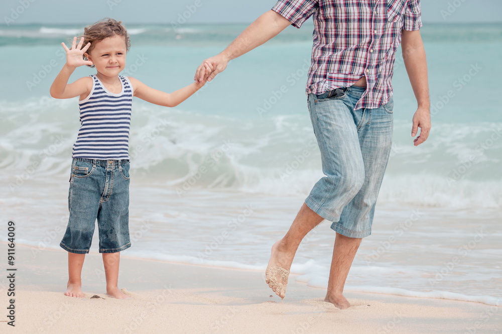 Father and son playing on the beach at the day time. Father and son playing on the beach at the day time.