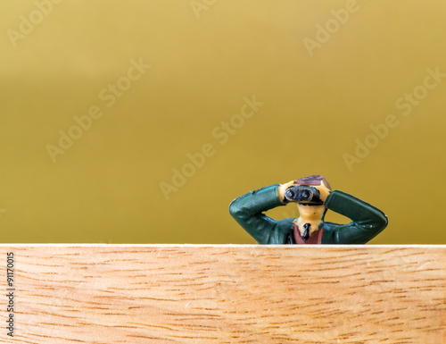 Male Model with Binoculars Spies over a Wooden Wall photo