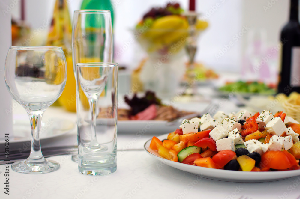 Dish salad for the holiday table. Serving. Wine glasses and drinks. Banquet table.