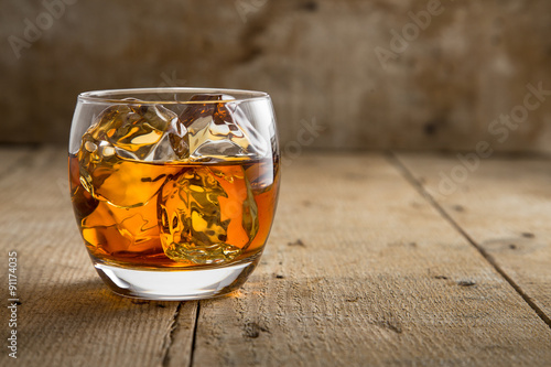 Fotografija Modern glass of scotch whisky old vintage wooden barrel background lifestyle pub
