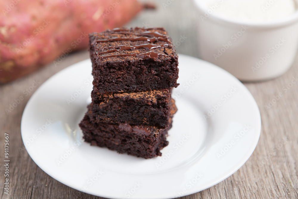 Healthy gluten free brownies made with sweet potato and coconut flour. Paleo style brownies on a wooden table, selective focus