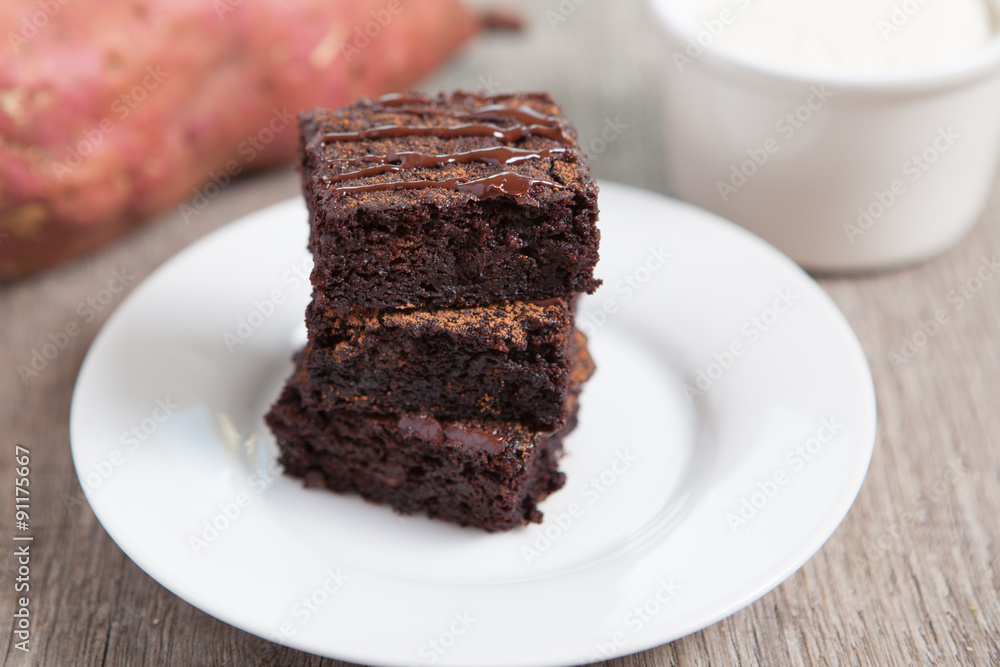 Healthy gluten free brownies made with sweet potato and coconut flour. Paleo style brownies on a wooden table, selective focus Healthy gluten free brownies made with sweet potato and coconut flour. Paleo style brownies on a wooden table, selective focus