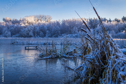Sunrise on winter lake cove...