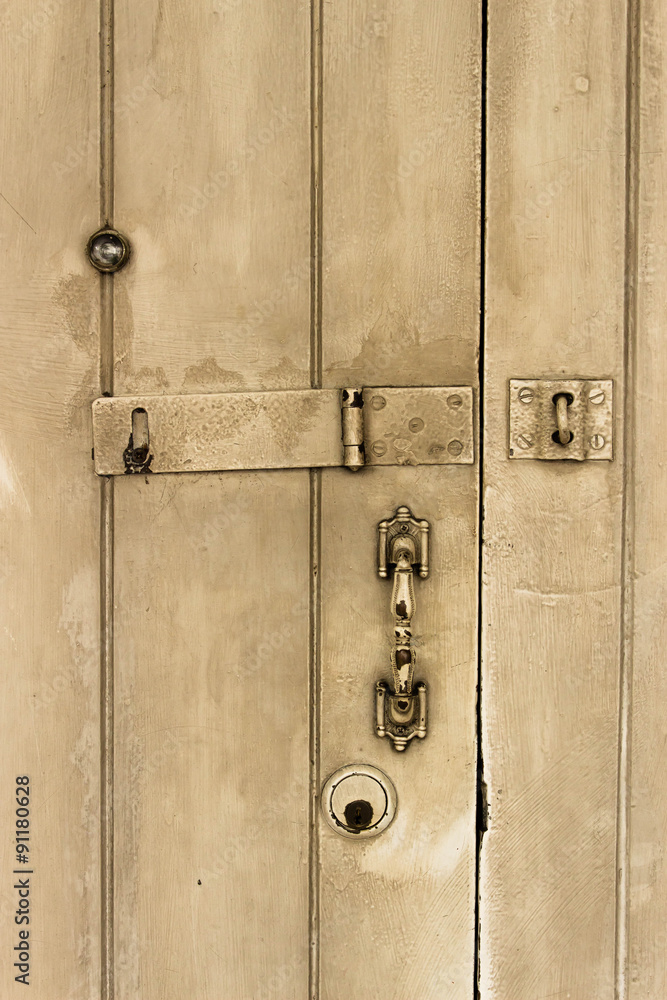 Fototapeta premium old wooden door with lock, handle, and eye hole.