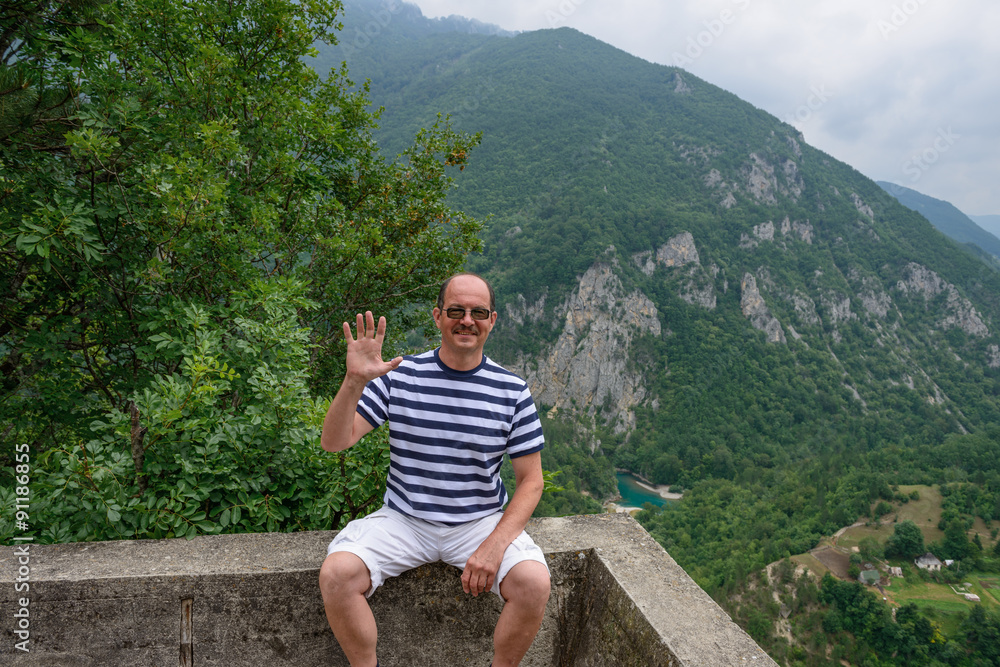 Obraz premium Man is posing on canyon of Tara river background, Montenegro.