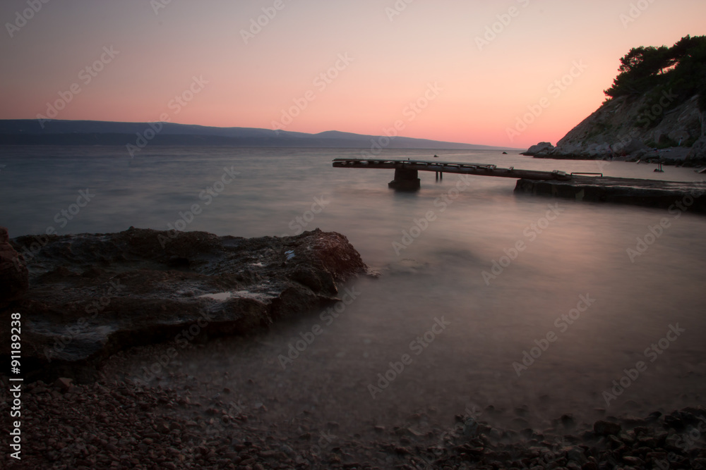 Sunset Beach with Piers and Wooden Breakwater with Late Sun Rays