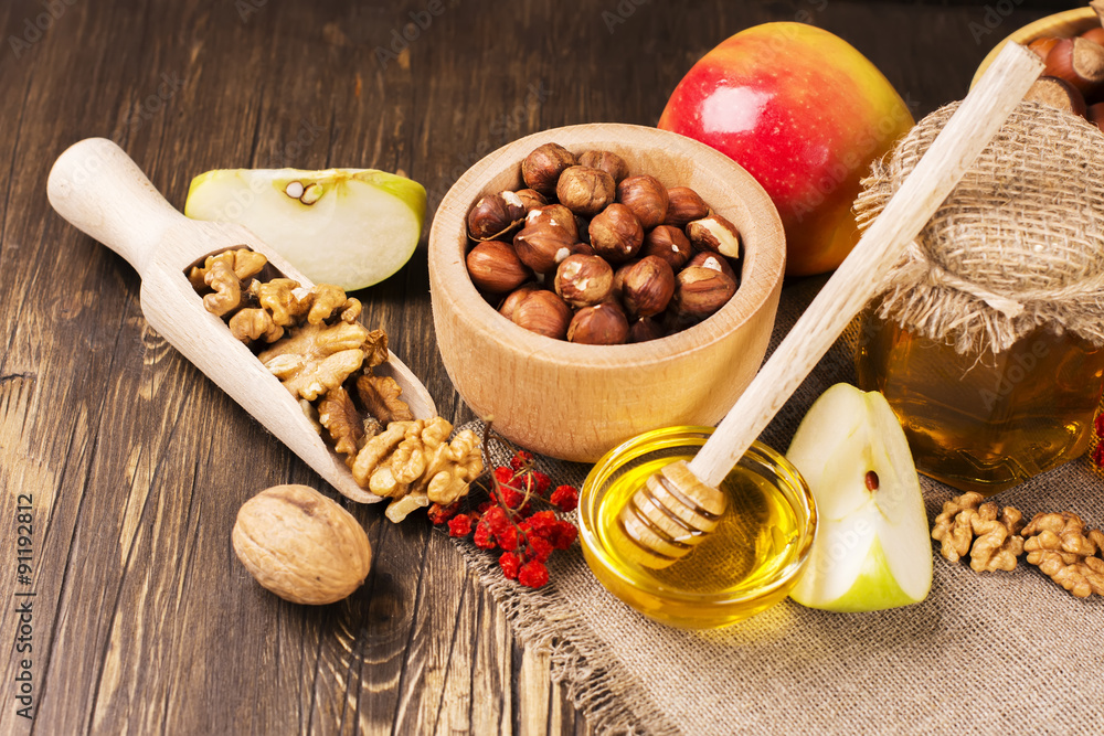 Autumn or harvest concept: assortment of nut, apples and honey. Selective focus Autumn or harvest concept: assortment of nut, apples and honey. Selective focus