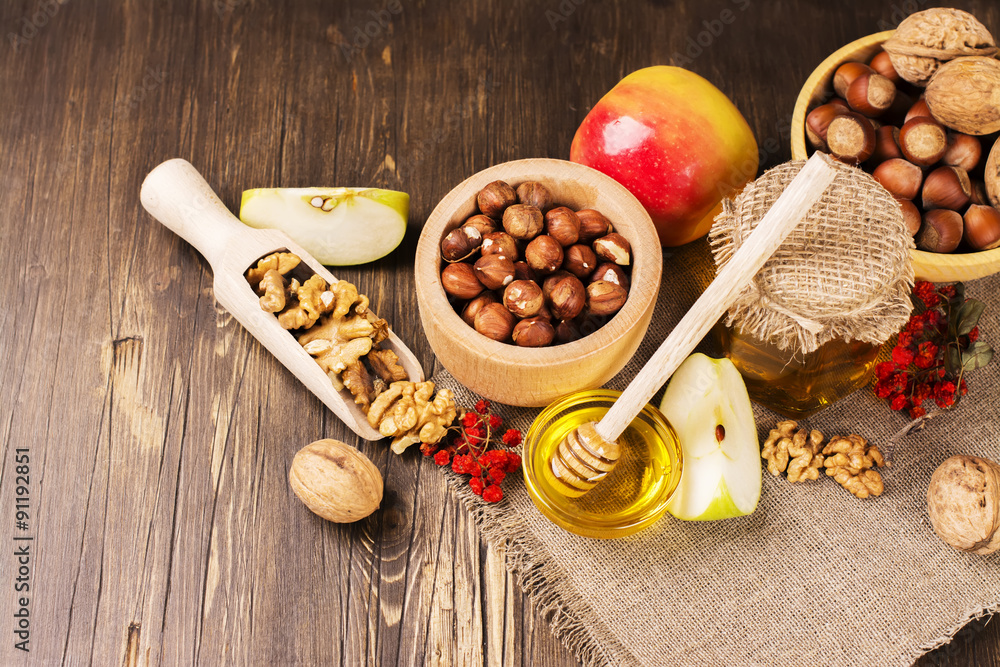 Autumn or harvest concept: assortment of nut, apples and honey. Selective focus Autumn or harvest concept: assortment of nut, apples and honey. Selective focus