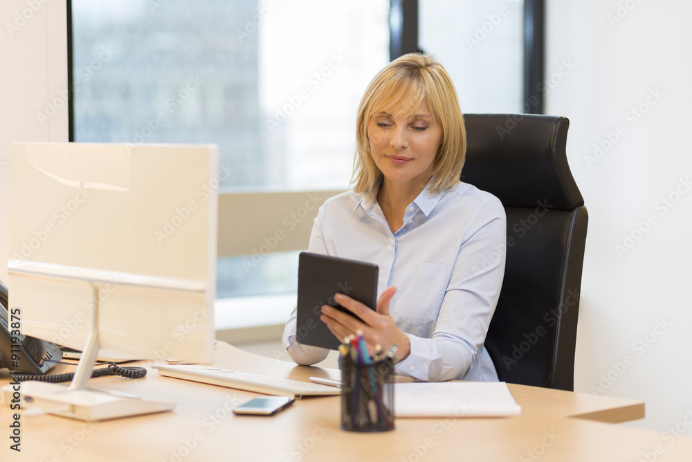 Middle aged business woman using tablet pc at office Middle aged business woman using tablet pc at office
