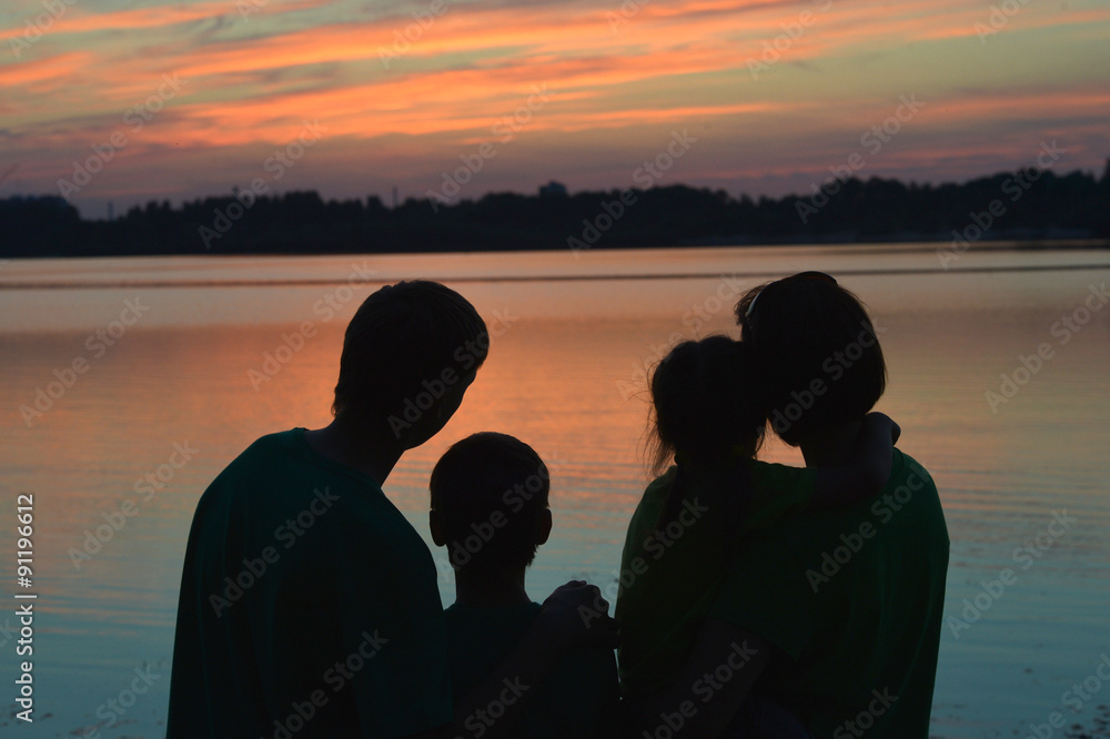 Silhouette, happy children with mother and father, family at sun