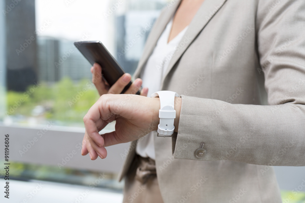 Naklejka premium Woman with Mobile phone connected to a smart watch