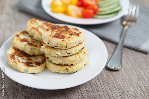 Vegetarian breakfast:  zucchini fritters made with coconut flour and a salad, selective focus