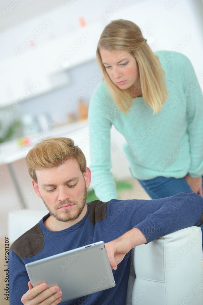 Obraz premium Couple have become dependent on their tablet computer