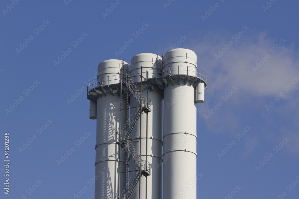 triple tube emits smoke against the blue sky triple tube emits smoke against the blue sky