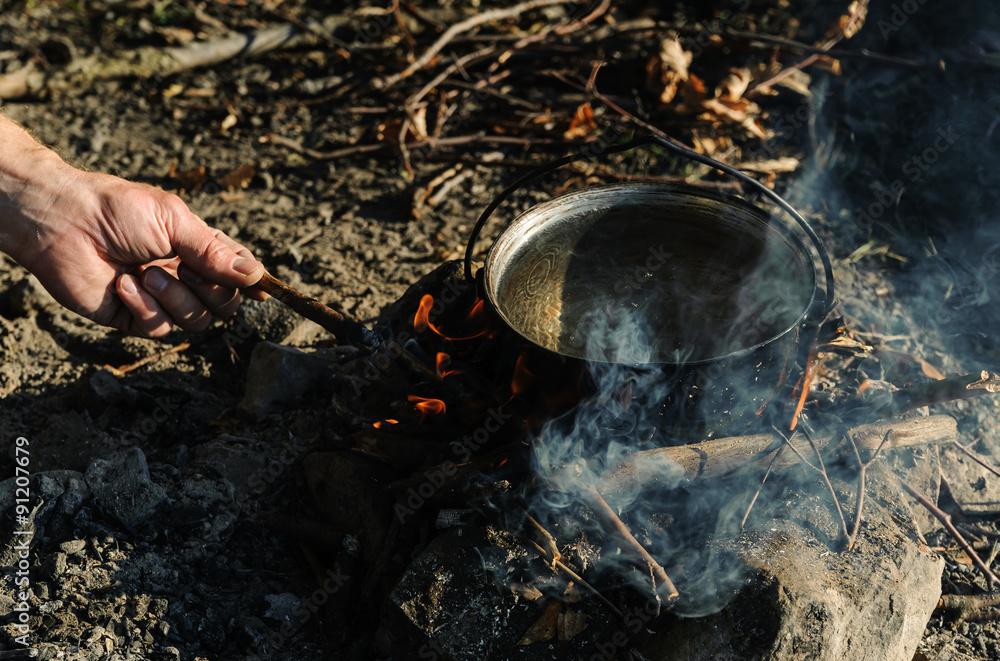 Kettle on charcoal fire. Kettle on charcoal fire.