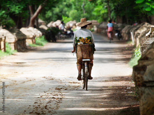 Murais de parede A burmese woman on the bicycle with some banana, Myanmar