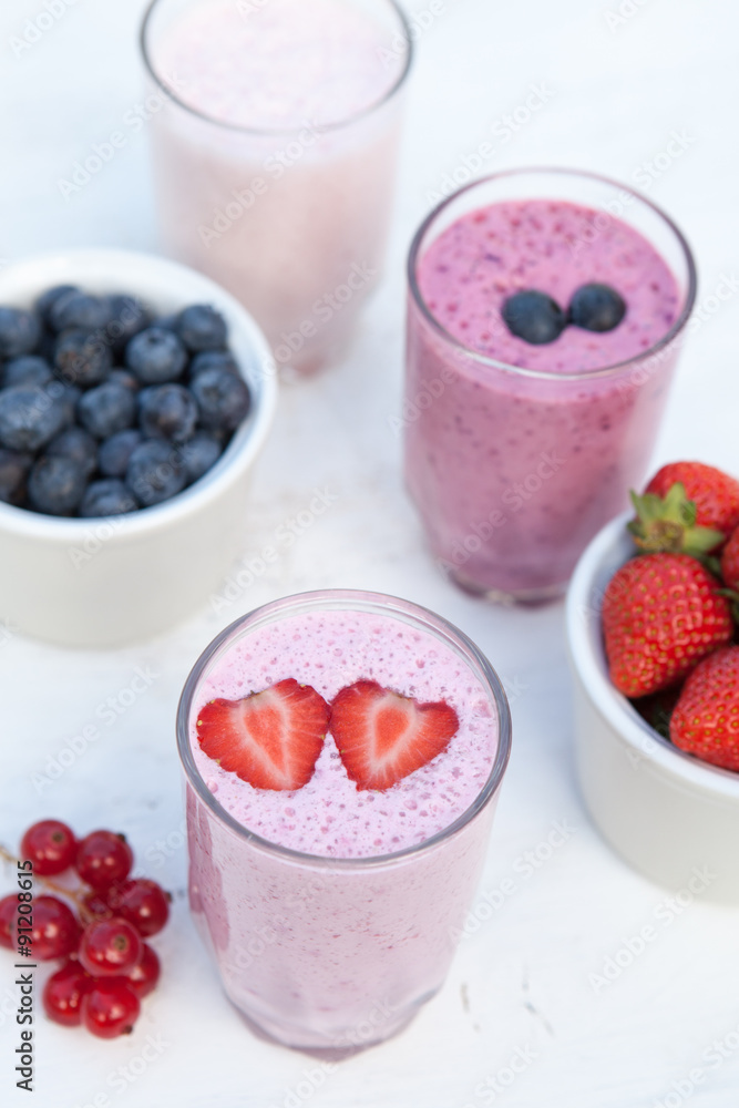 Three small glasses of smoothie on the white table in the garden Three small glasses of smoothie on the white table in the garden