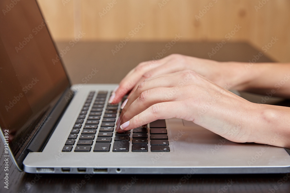 Woman typing on a laptop computer Woman typing on a laptop computer