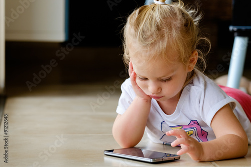 A cute girl playing with a smartphone