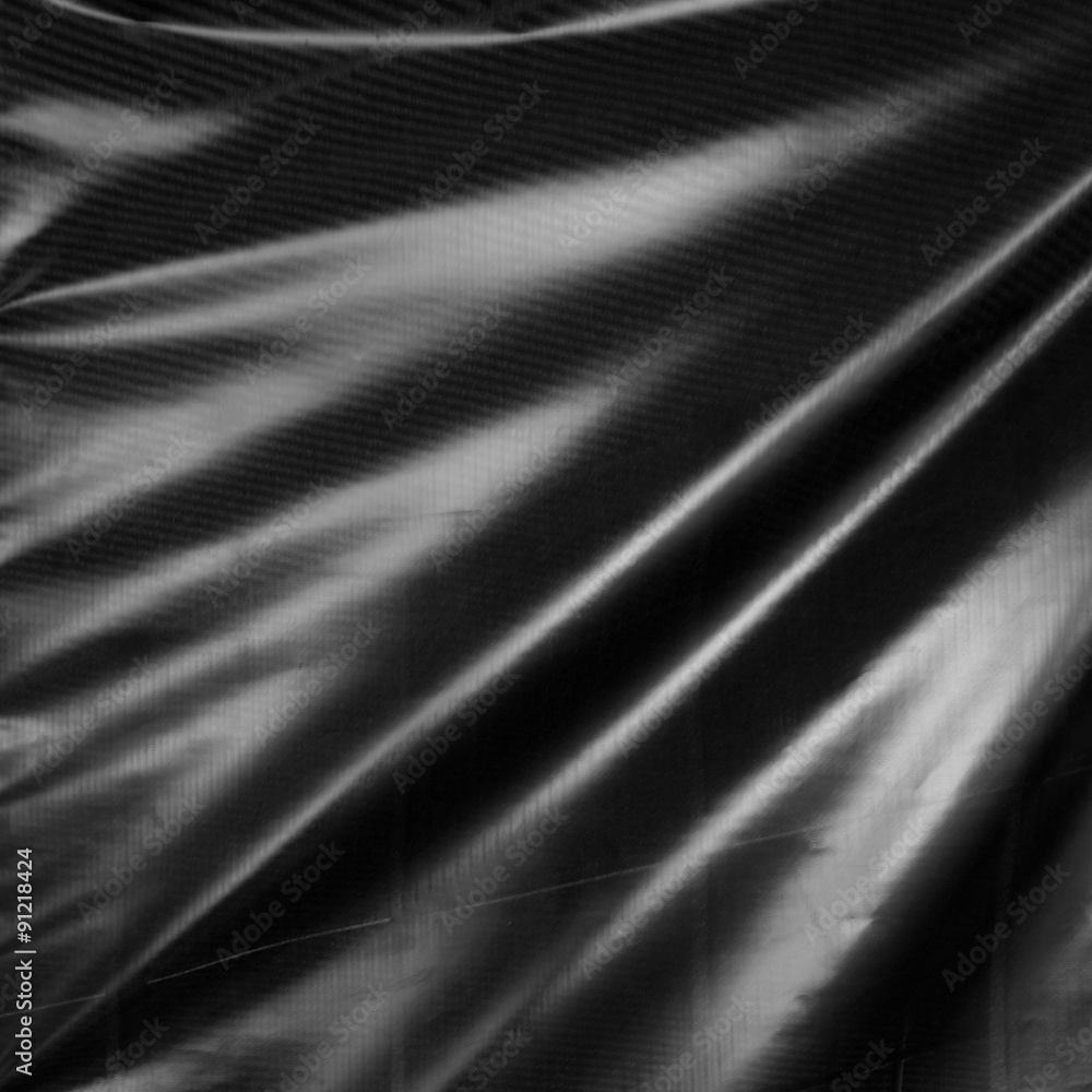 Fototapeta premium Black drape. Wavy folds of synthetic material.