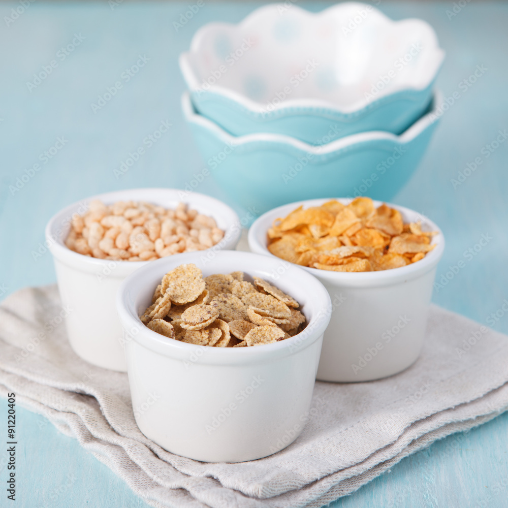 Mixed cereals in the blue bowl with empty bowls on the backgroun Mixed cereals in the blue bowl with empty bowls on the backgroun