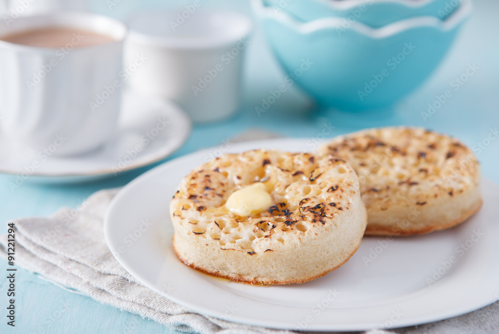 Hot buttered crumpets on the blue table with tea Hot buttered crumpets on the blue table with tea