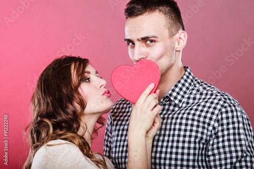 Loving couple kissing behind red heart. Love.