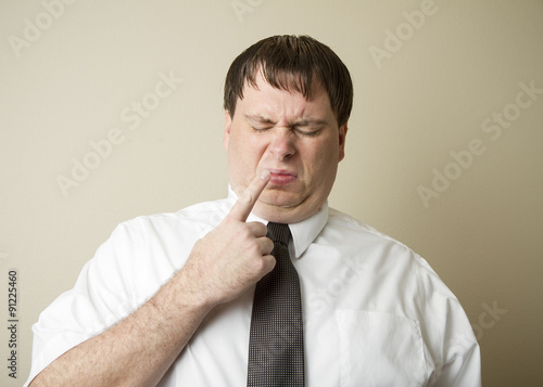 Man with his finger by his nose photo