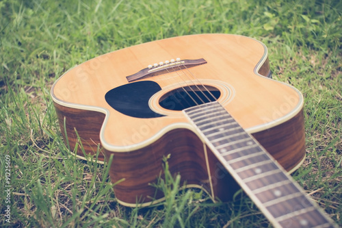 Acoustic guitar on grass with vintage tone and soft focus photo