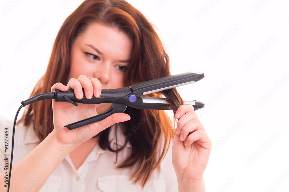 Fototapeta premium Hair straightener in woman's hand