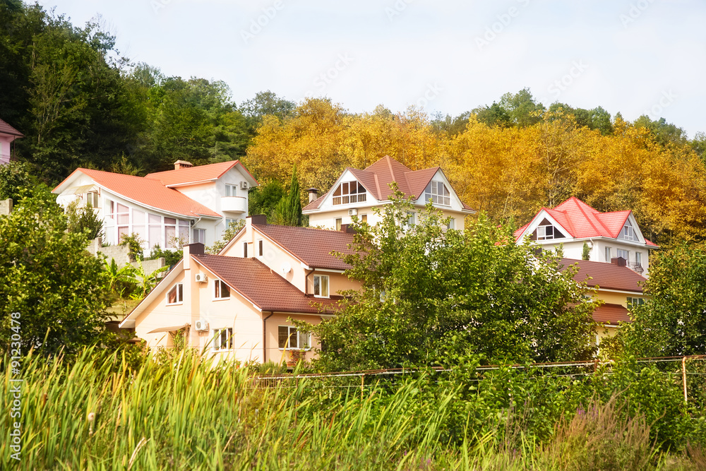 Cottage houses in picturesque autumn forest