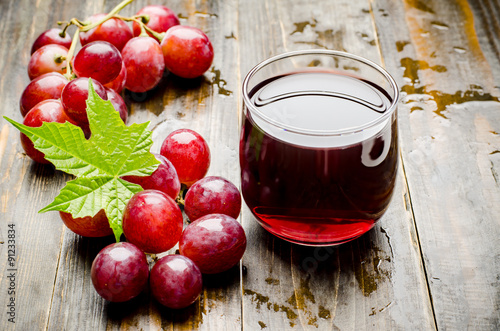 Red grape and juice on wooden background,healthy drink