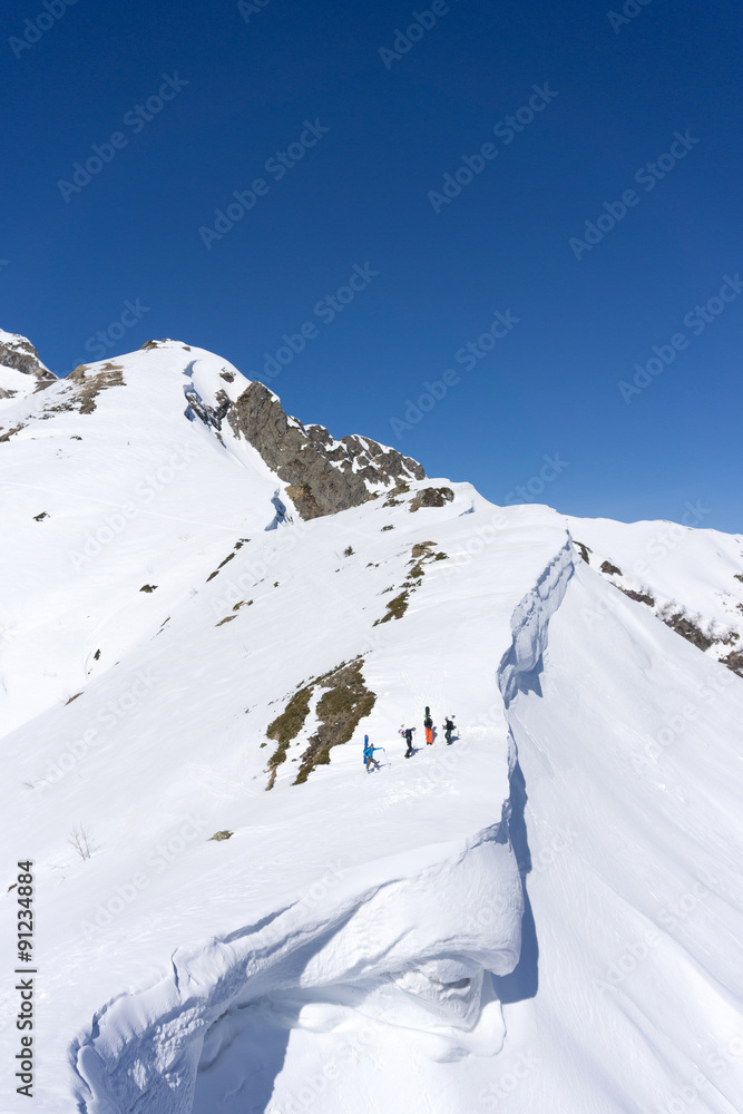 Obraz premium Snowboarders walking uphill for freeride