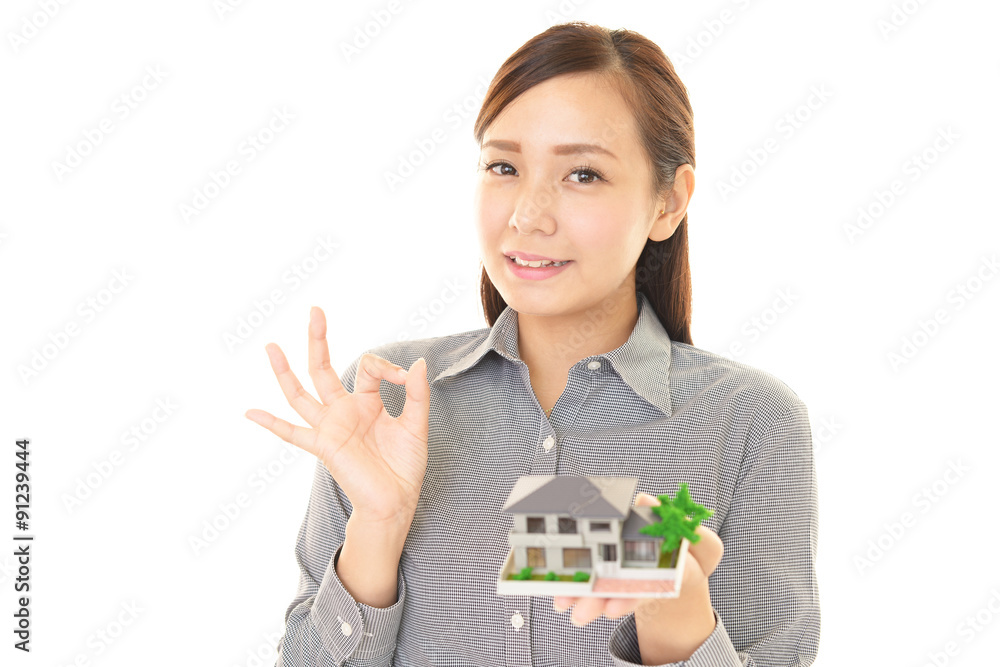 家の模型を持つ女性