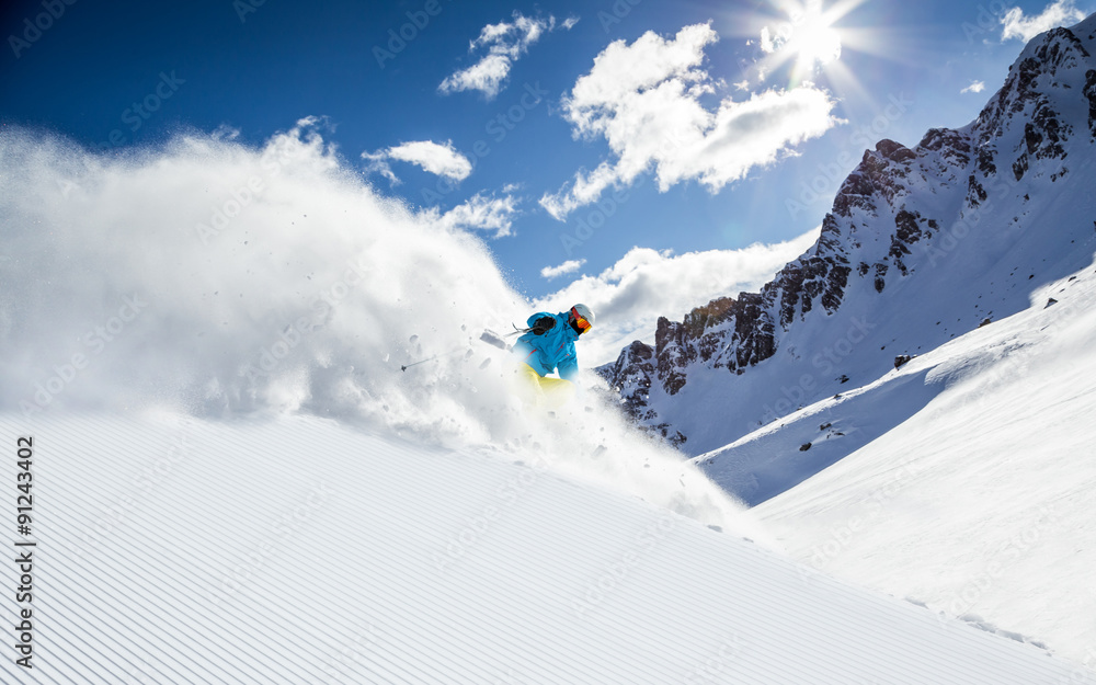 Skier skiing downhill in high mountains