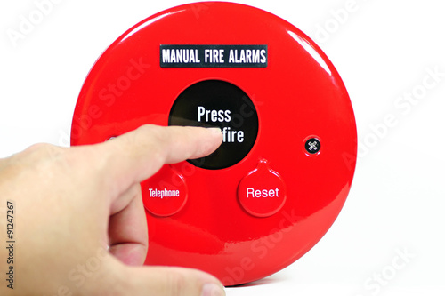 Finger pressing on manual fire alarm