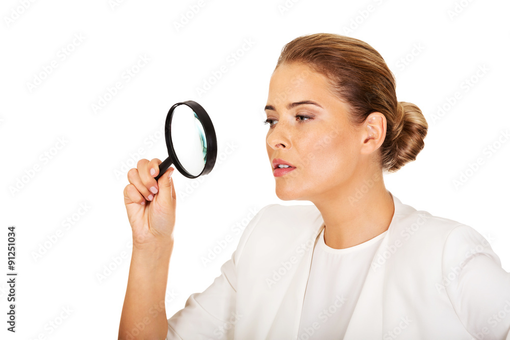 Young attractive businesswoman looking into a magnifying glass Young attractive businesswoman looking into a magnifying glass