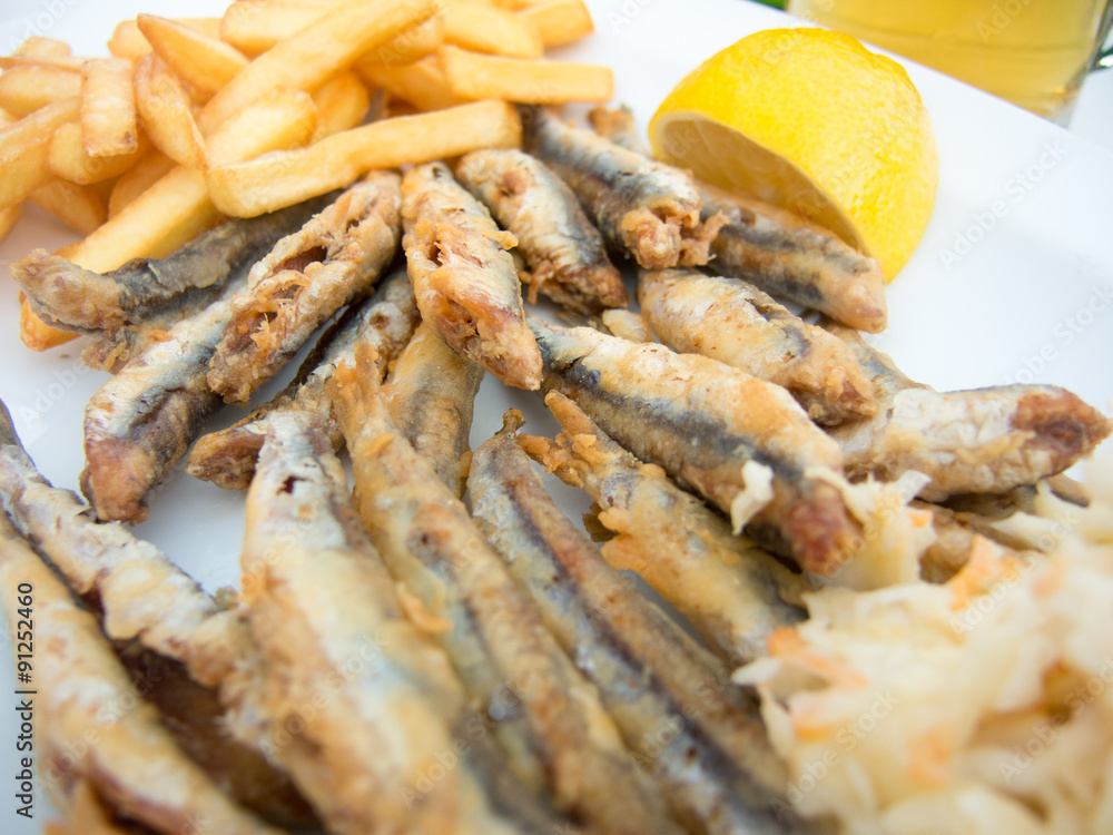 fried anchovy on a plate with fries fried anchovy on a plate with fries