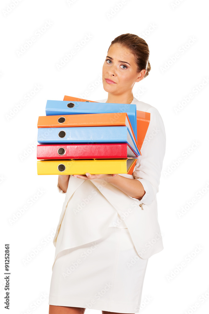 Tired businesswoman carrying heavy binders Tired businesswoman carrying heavy binders