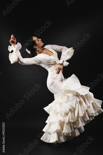 Young woman performing salsa dance with passion on black backgro