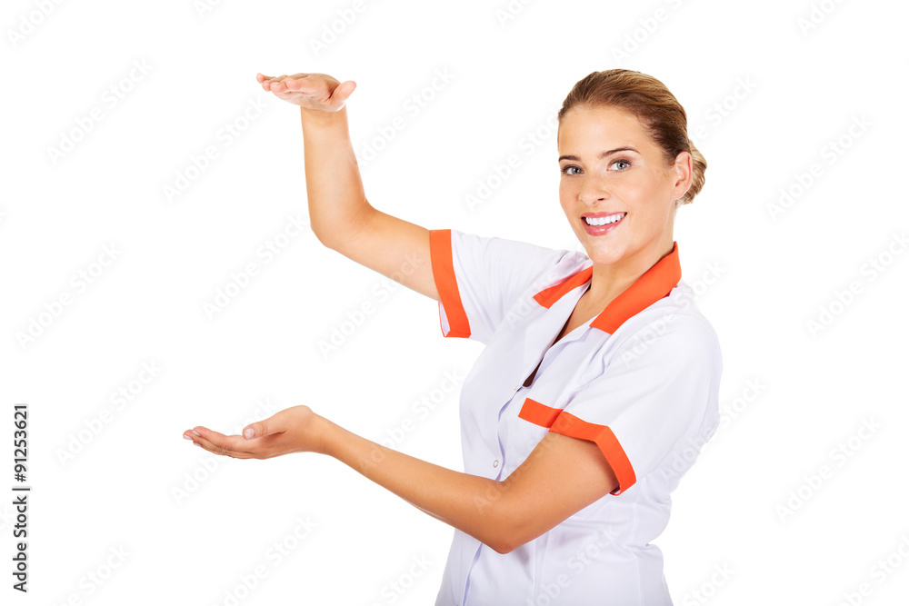 Smiling female doctor or nurse hold something Smiling female doctor or nurse hold something