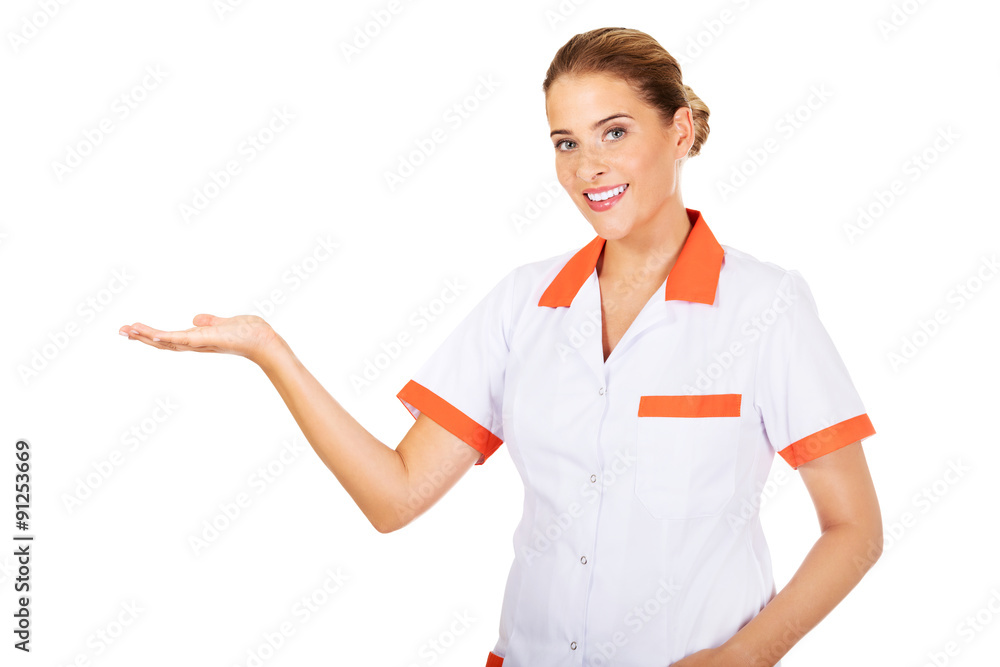 Smiling female doctor or nurse pointing at something Smiling female doctor or nurse pointing at something