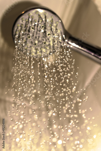 Water drops close-up dripping from the shower warm filtered