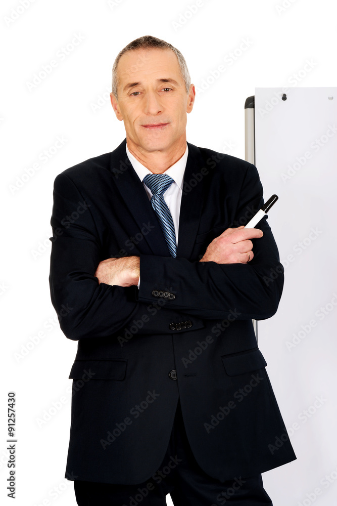 Male executive standing near flip chart Male executive standing near flip chart