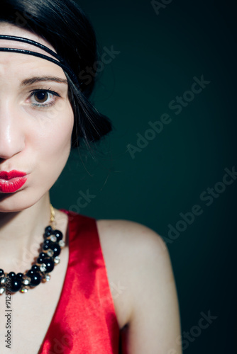 Closeup of elegant young woman wearing 1920s styled red costume 