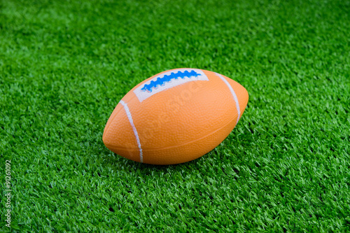 Toy football on artificial grass background