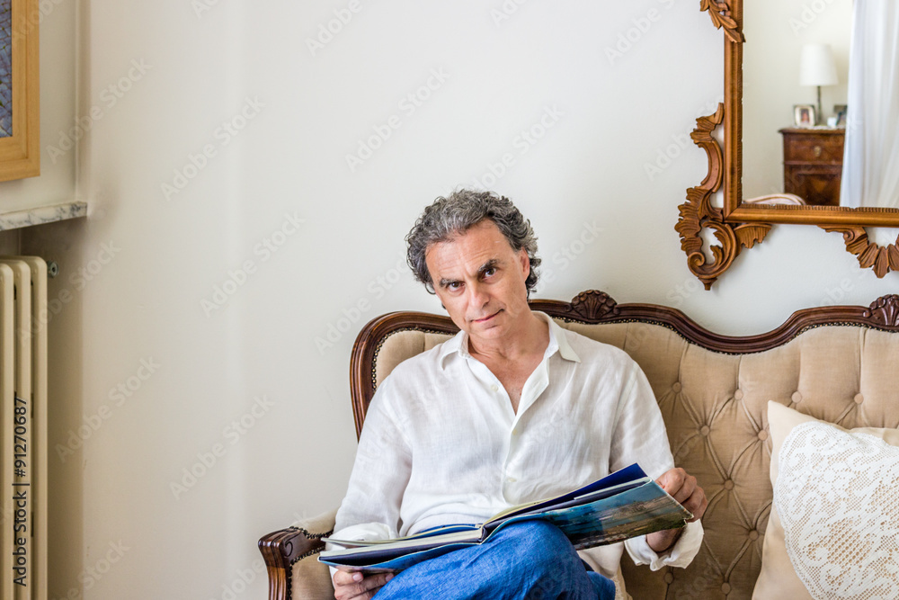 Charming forties reading photo book in living room
