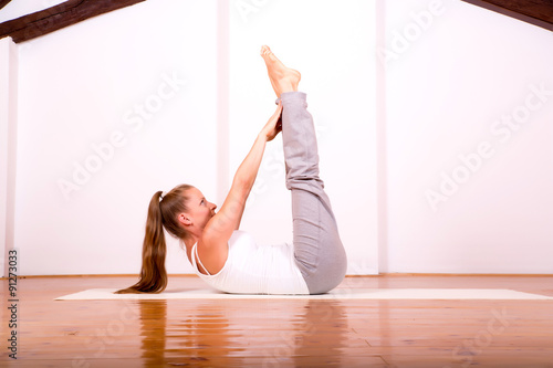 Woman practicing Yoga in a Studio.